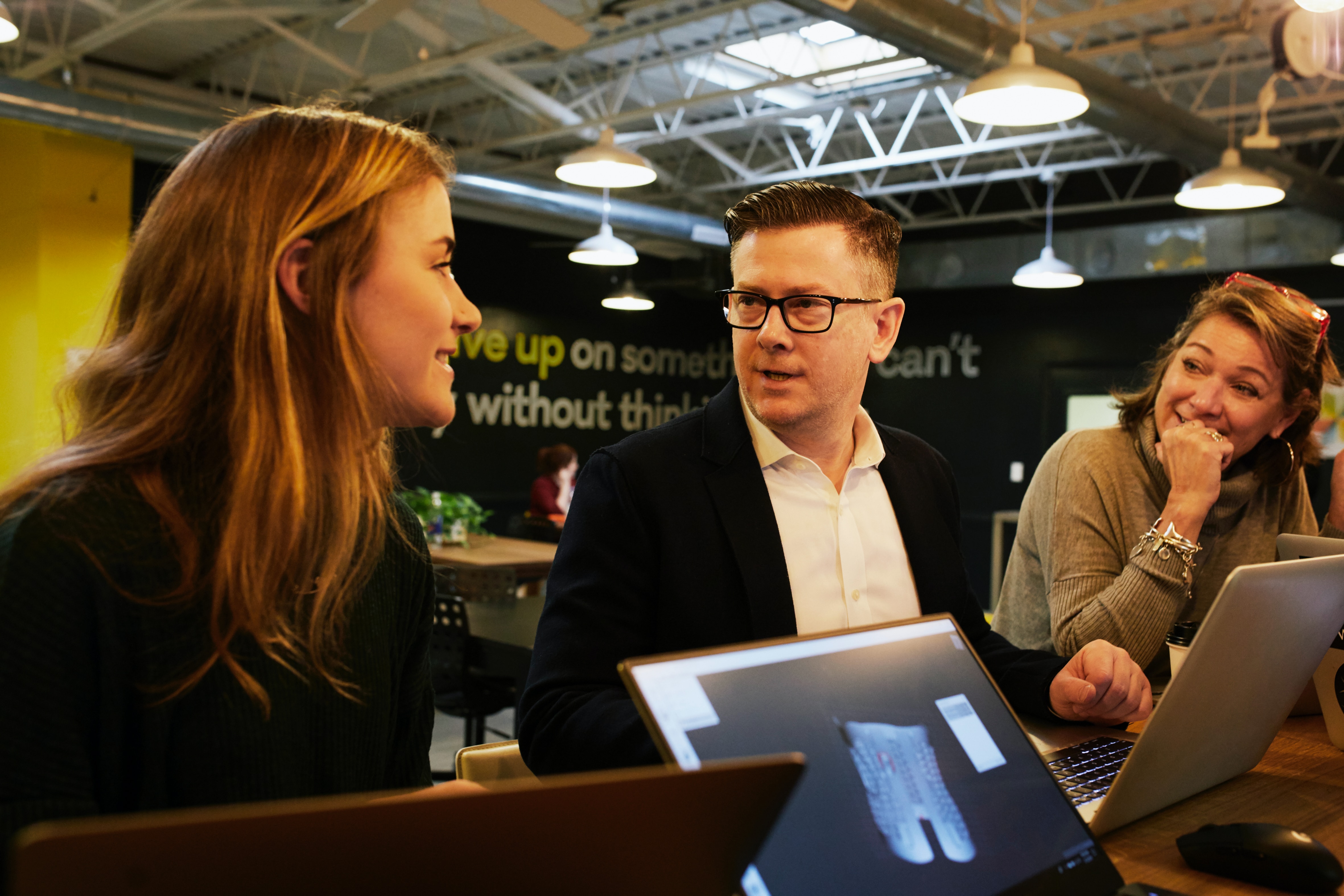Business Development team members aligning on tasks using a laptop